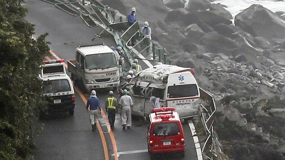 Police and Fire department officers check vehicles swept away by high waves caused as a strong typhoon hits Odawara, Kanagawa Prefecture, southwest of Tokyo, Japan, 29 July 2018