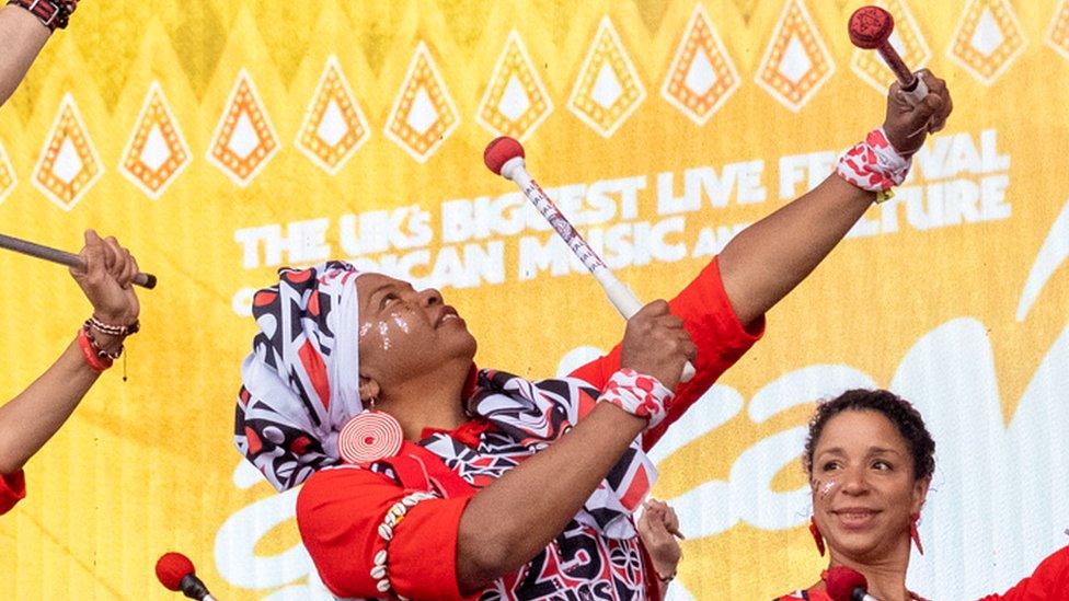 Ladies perform in drumming group on stage