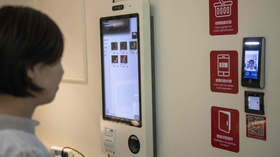 A woman paying for her shopping by looking into a screen at a supermarket in China