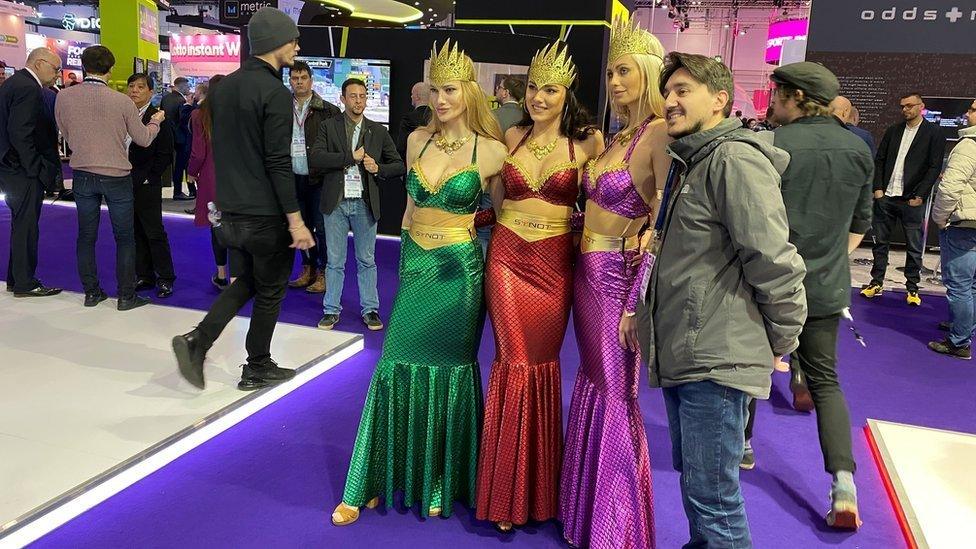 Flavio Grasselli stands with three women dressed as mermaids