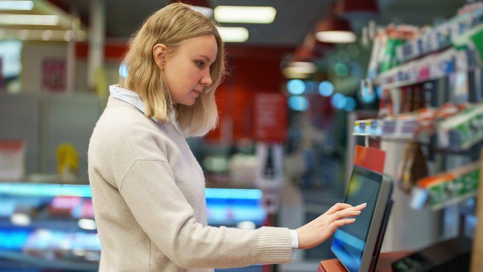 Woman paying at a self service till