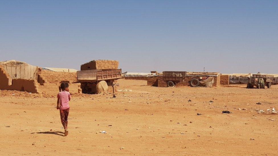 A little girl walks near makeshift shelters at Rukban camp, on the Syria-Jordan border (27 September 2018)