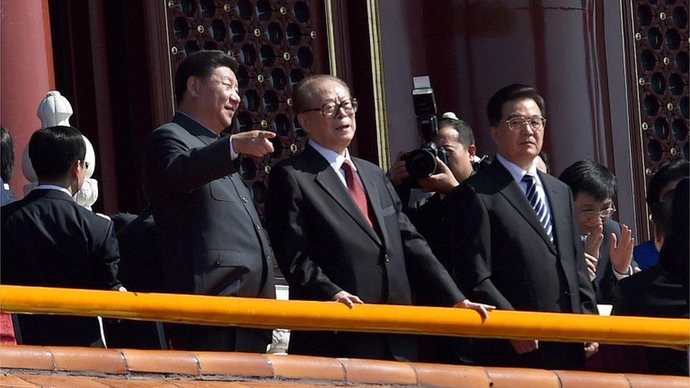 China's President Xi Jinping (L) talks to former president Jiang Zemin (C) as former president Hu Jintao (R) looks on, during a military parade in Tiananmen Square in Beijing on 3 September 2015, to mark the 70th anniversary of victory over Japan and the end of World War Two