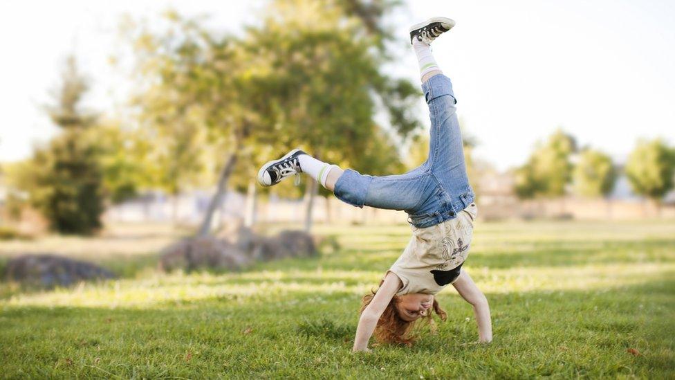 girl-doing-cartwheel-in-park