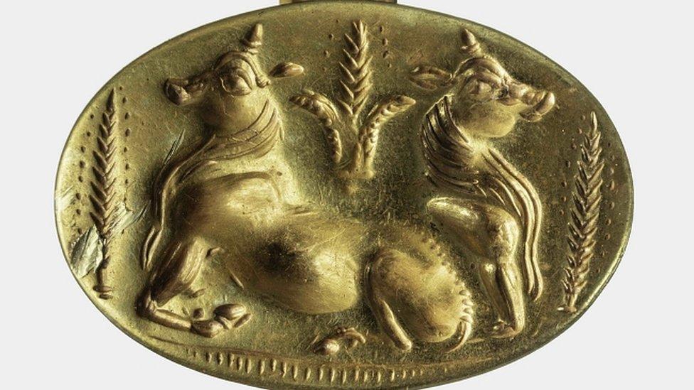 Gold ring depicting two bulls and sheaves of barley