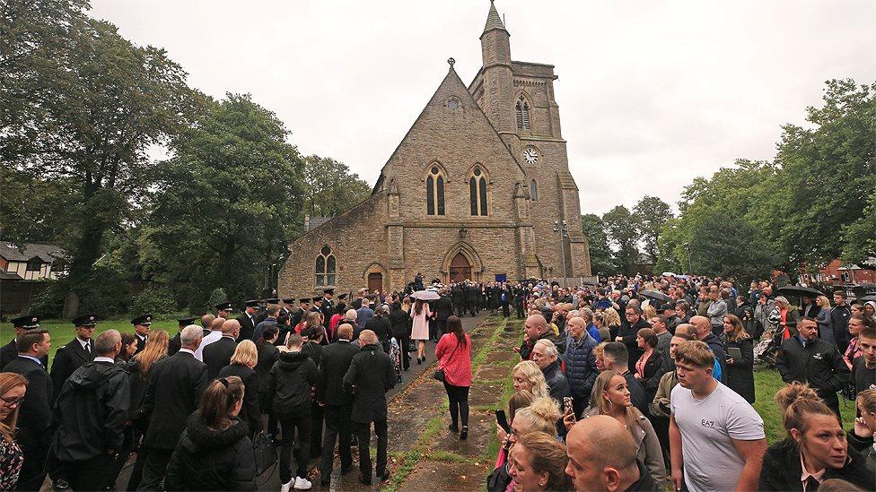 Mourners outside the church