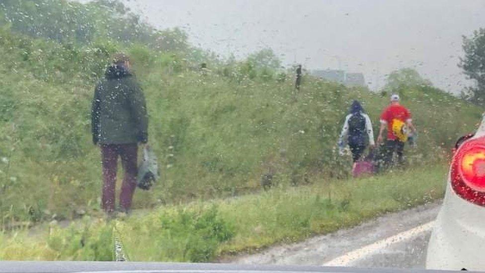 Holidaymakers walking down A453