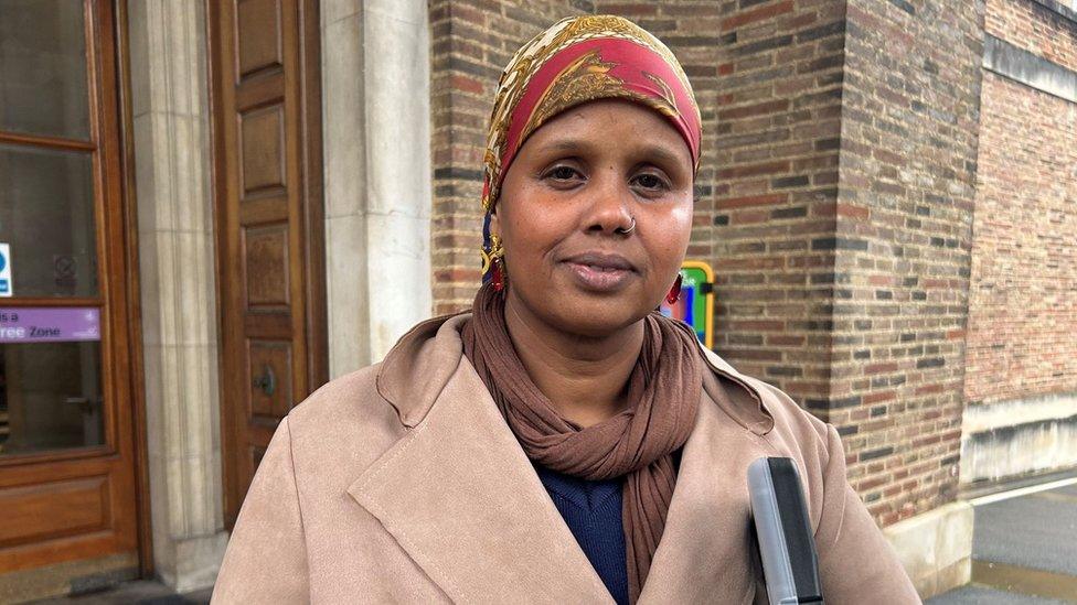 Fatima Bashir, Barton House resident, wearing a gold and red head scarf and a beige coat