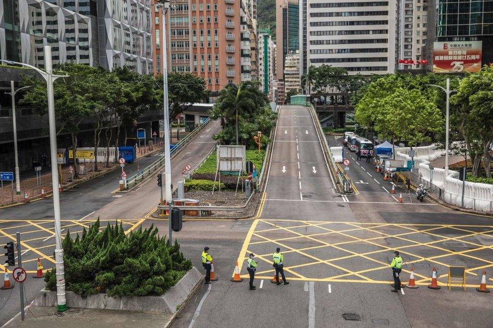 Police stand guard on a street in Hong Kong on July 1, 2022, during the 25th anniversary of the city's handover from Britain to China