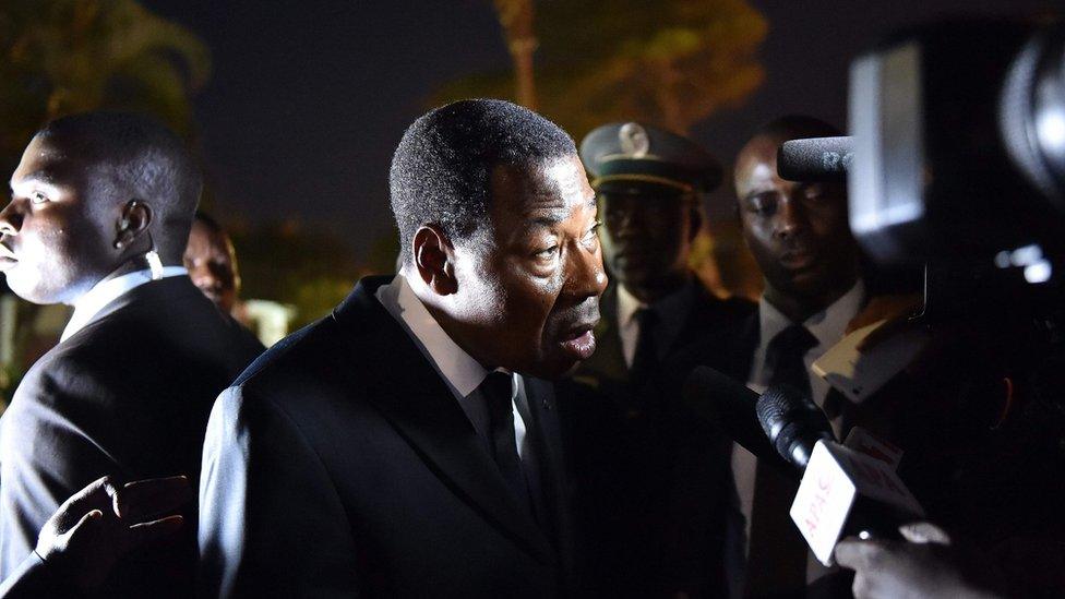 On Tuesday in Ivory Coast, camera lights illuminate the face of Benin's President Thomas Boni Yayi, who visited the beach town of Grand Bassam to show solidarity, following an attack by Islamist militants which killed at least 19