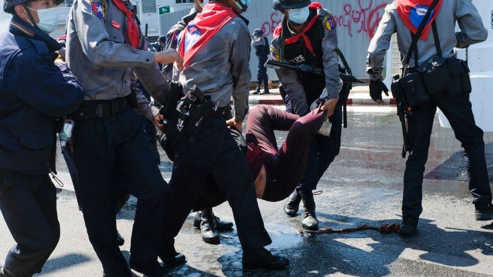 Police carry a protester