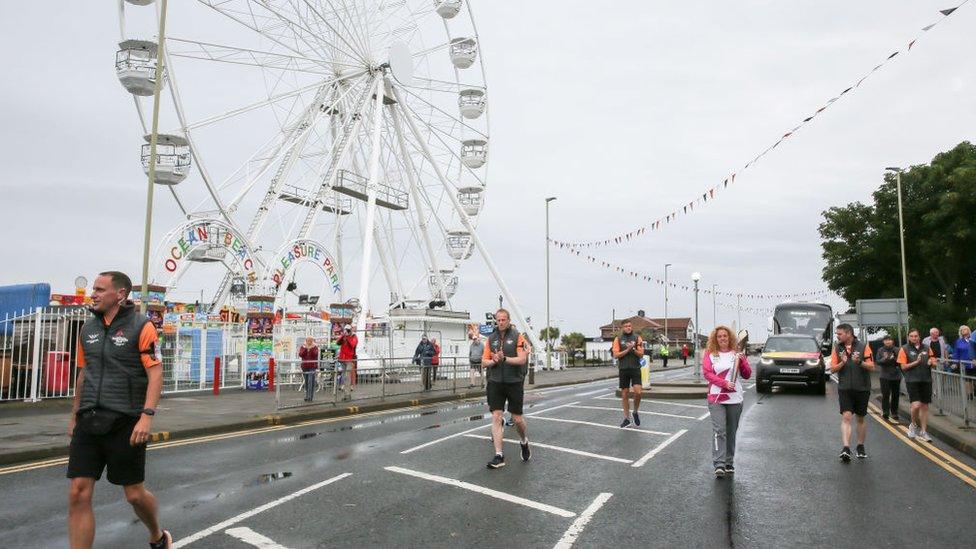 Angie Comerford runs with the baton along South Shields seafront