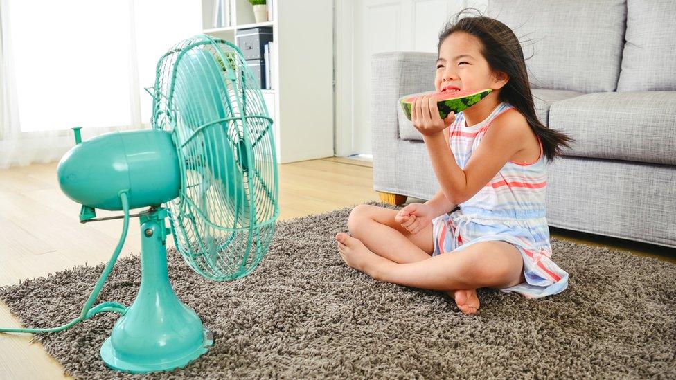 girl-sitting-near-fan-eating-watermelon.