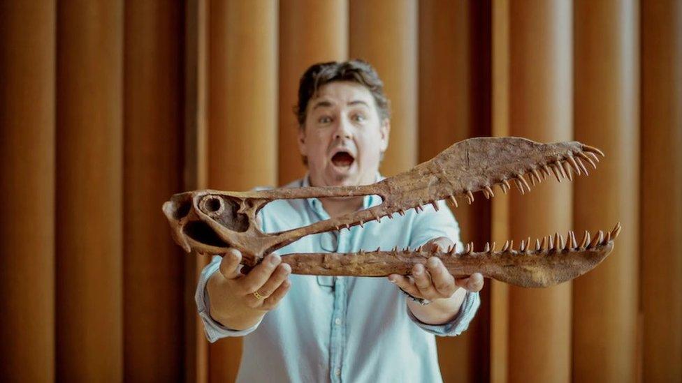 Tim Richards from the University of Queensland's dinosaur lab holds the skull of Thapunngaka shawi.