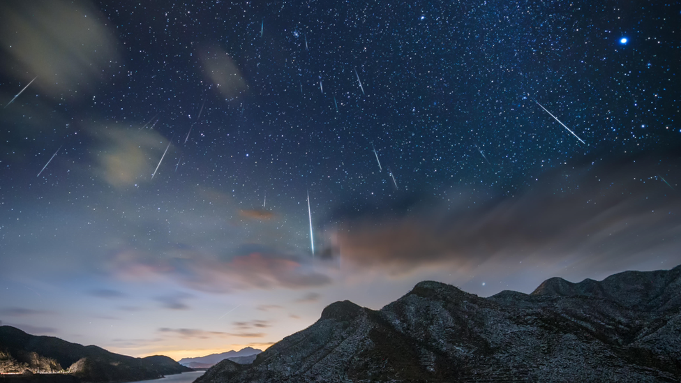 shooting stars over a mountain at night