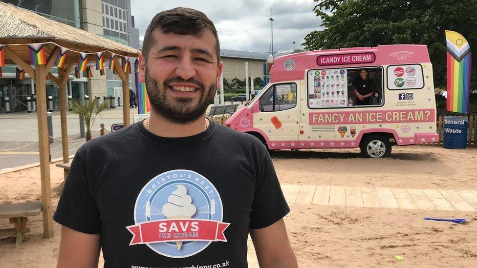 Sav Gino, ice cream vendor smiling at the camera with his pink ice cream van in the background