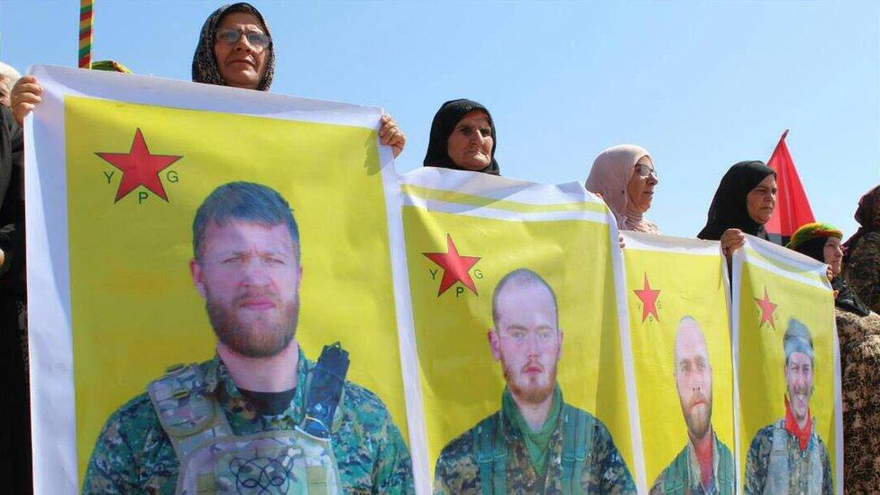 Women holding flags showing dead soldiers