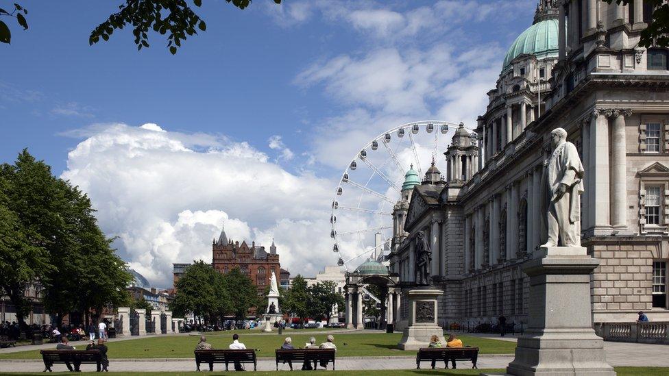 A picture of Belfast with people sitting on benches