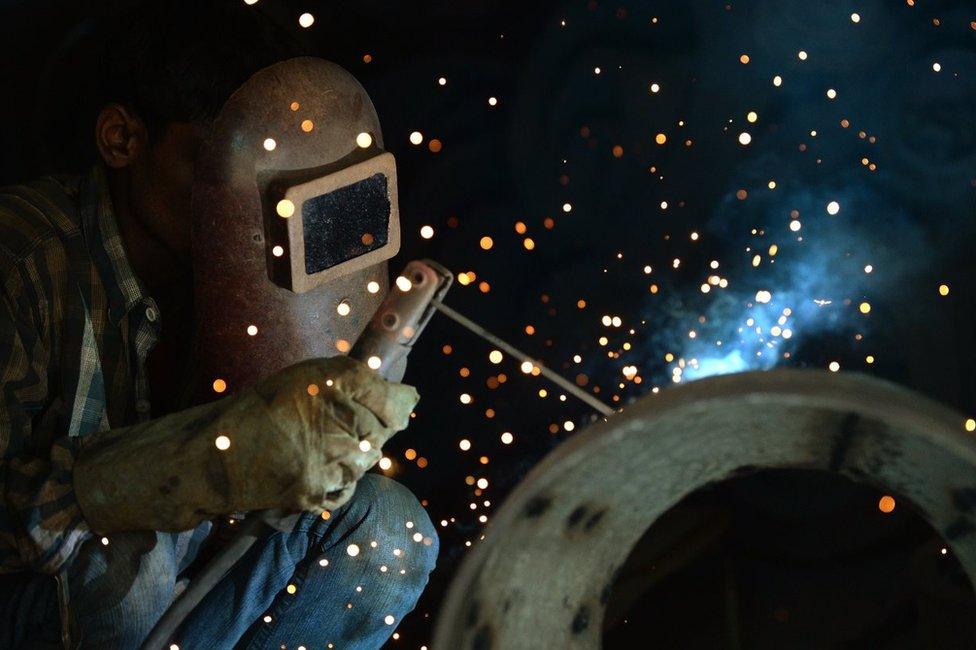 In this photograph taken on May 28, 2015, an Indian labourer uses a welding torch at a roadside metal shop in Mumbai. India's factory output rose to a four-month high in May on increased demand, a survey showed June 1, 2015, in a further boost for the economy after data showed it was outgrowing China.