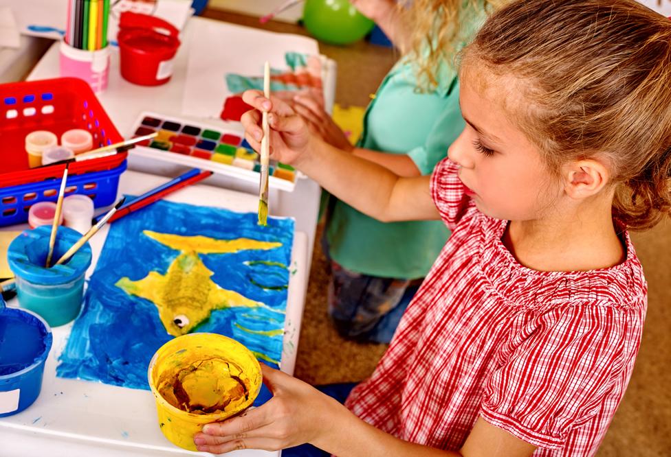 Child painting with yellow