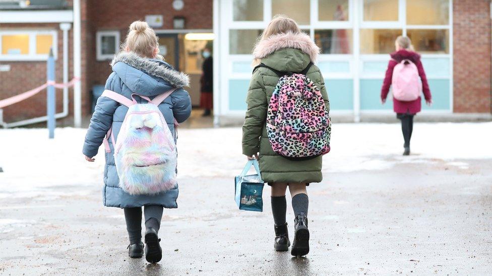 Girls walking towards a school