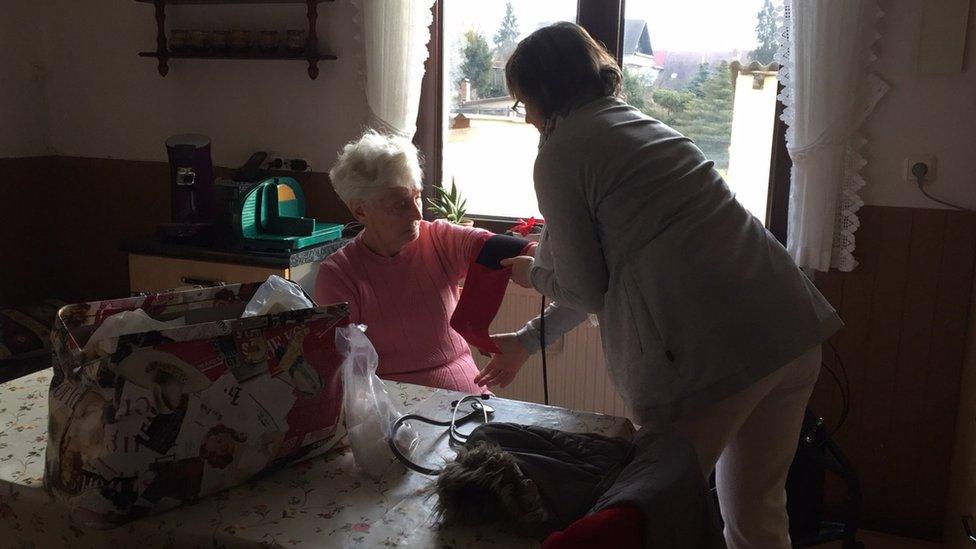 A community nurse treats a patient