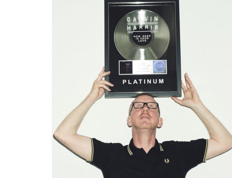 Dave Rowntree balances Calvin Harris' platinum disc above his head