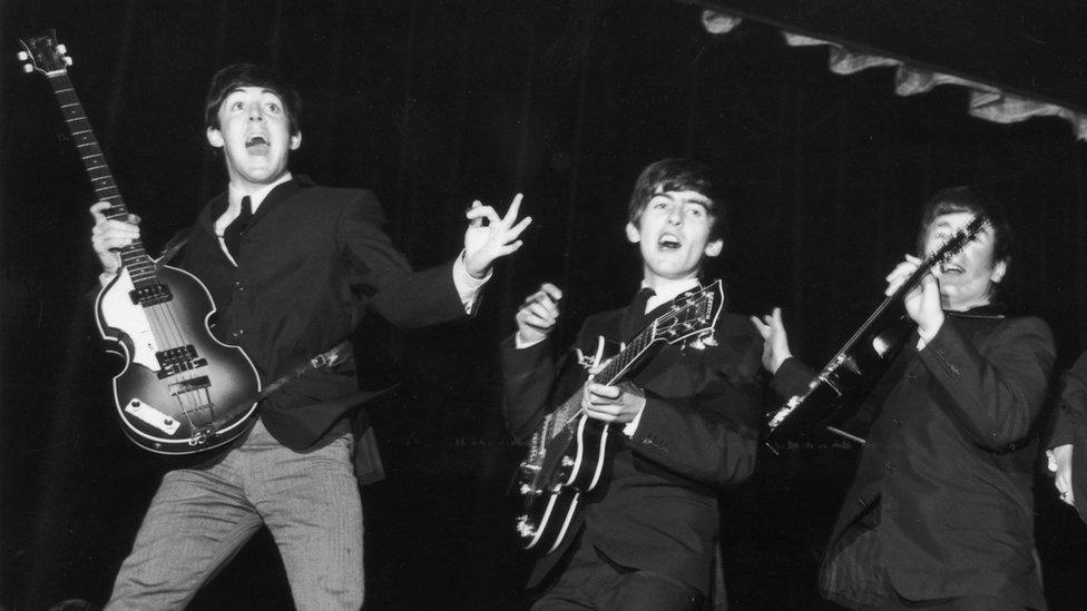 Paul McCartney, George Harrison (1943 - 2001), John Lennon (1940 - 1980) and Ringo Starr, jump for joy during a rehearsal for the Royal Command Performance at the Prince of Wales Theatre.