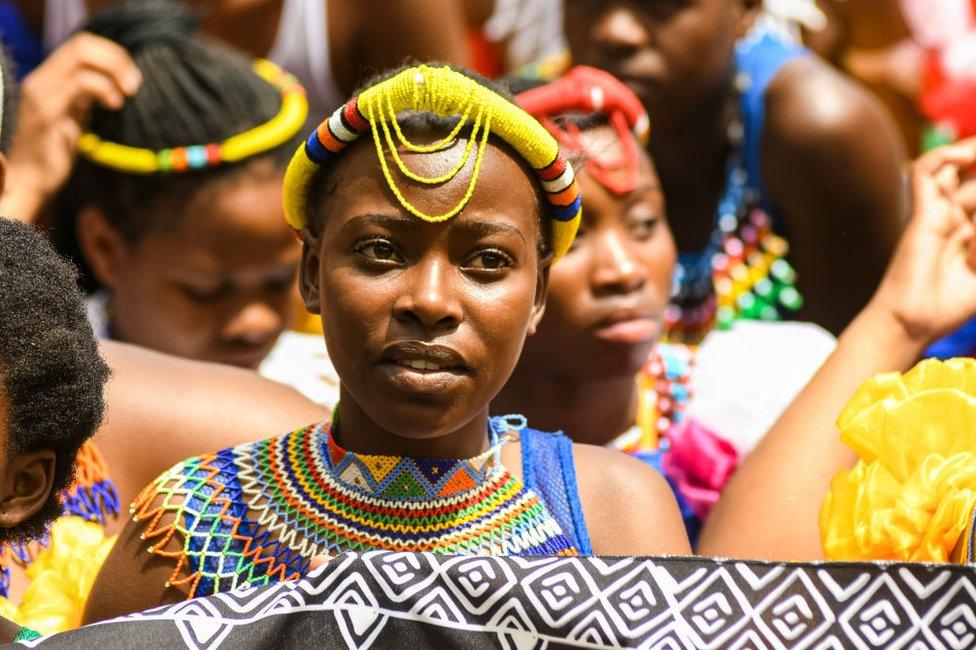 Women wearing traditional Zulu attire stand in Moses Mabhida Stadium.