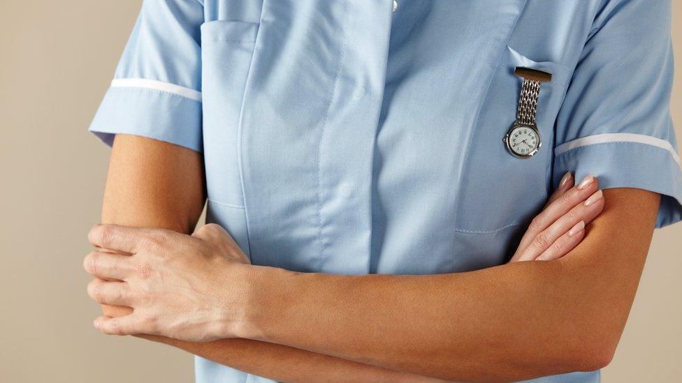 Nurse standing with arms folded