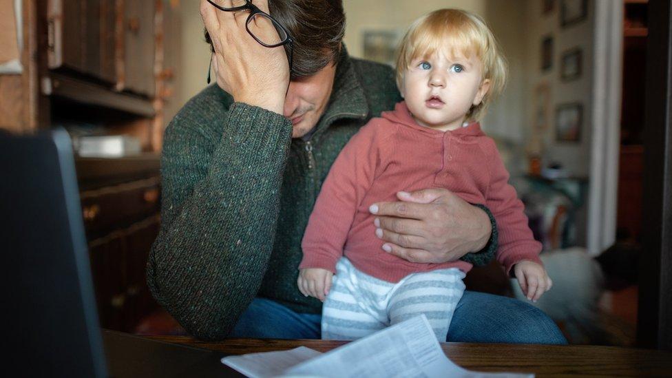 A man upset holding his young son