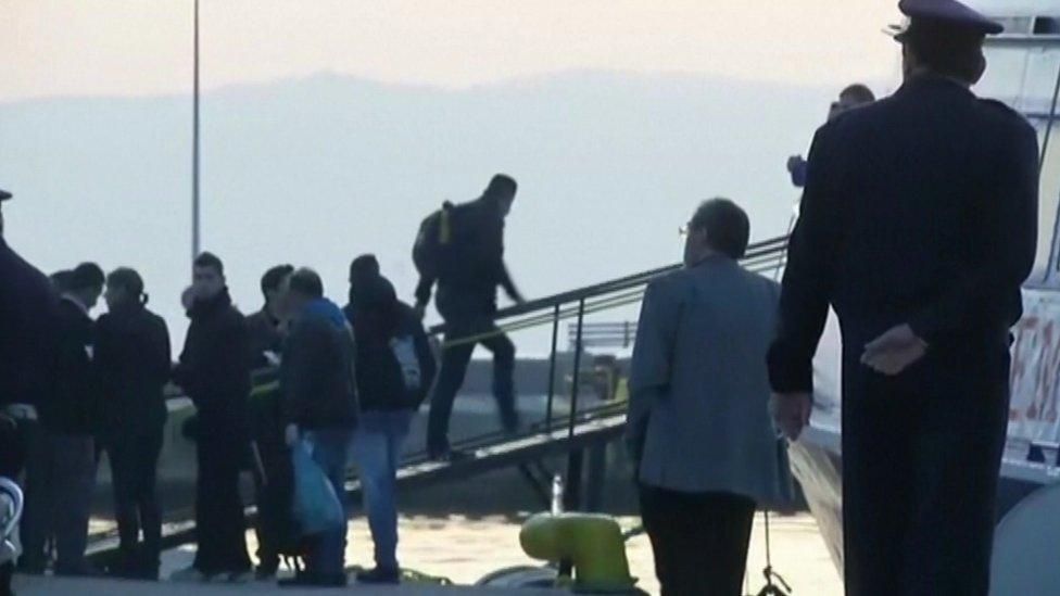 Migrants and Greek security forces at the Greek island of Lesbos