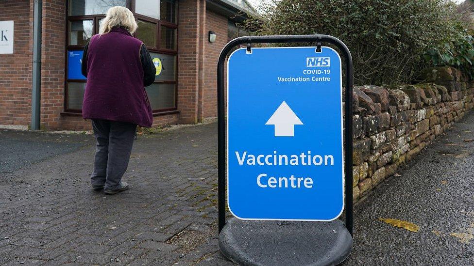 woman walking into vaccination centre