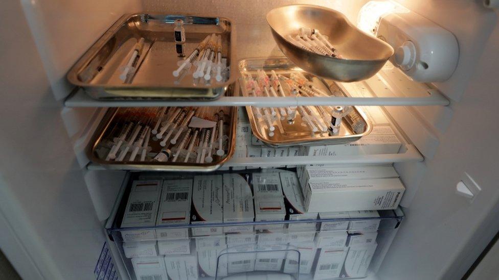 Syringes with doses of the Pfizer Covid-19 vaccine are seen in a fridge