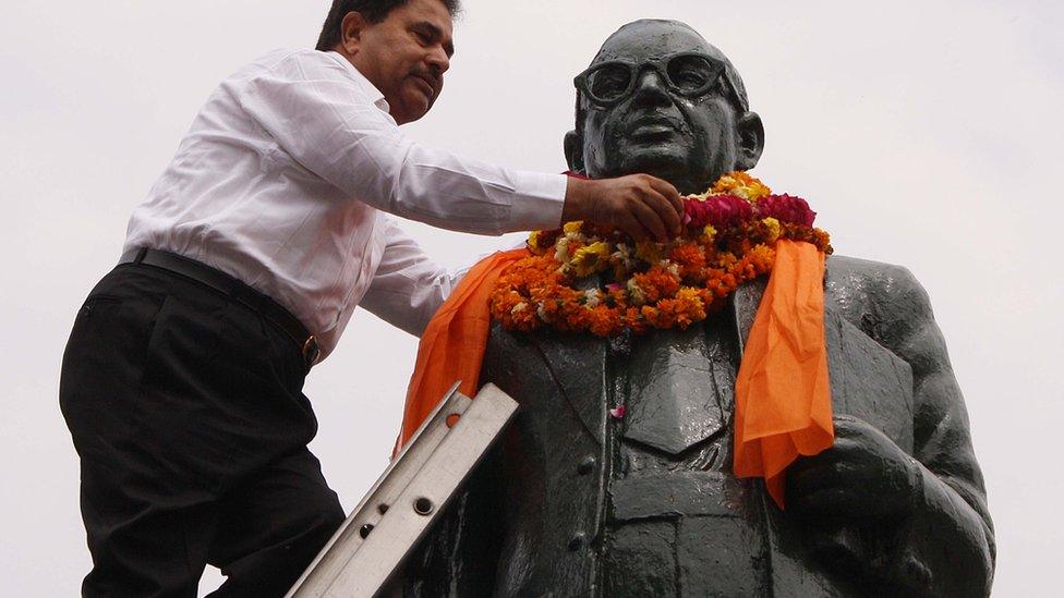 An Indian garlands a statue of BR Ambedkar