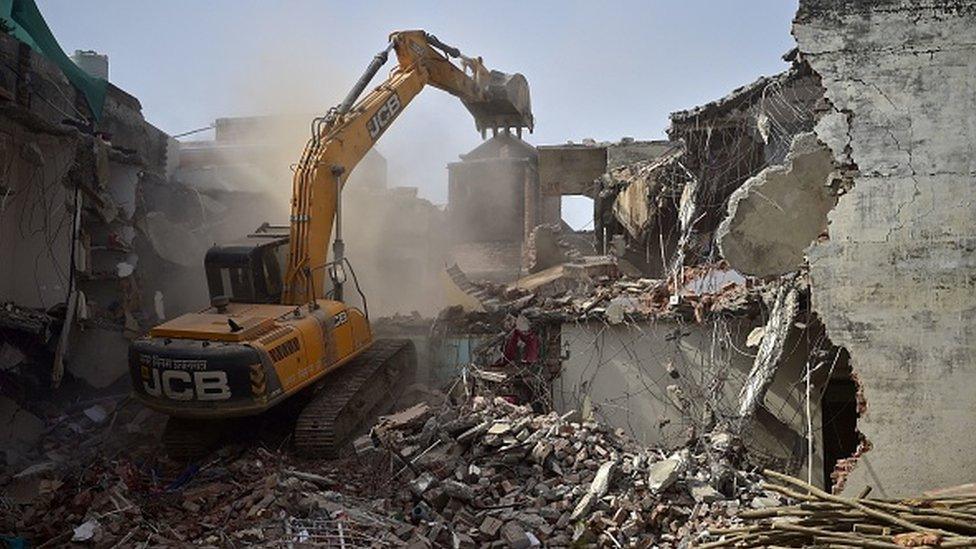 A bulldozer is being used to demolish the illegal structures of the residence of Javed Ahmed, a local leader who was allegedly involved in the recent violent protests against Bharatiya Janata Party (BJP) former spokeswoman Nupur Sharma's