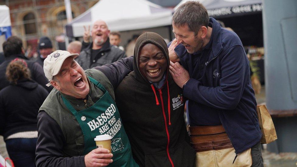 Three traders at the food festival laughing