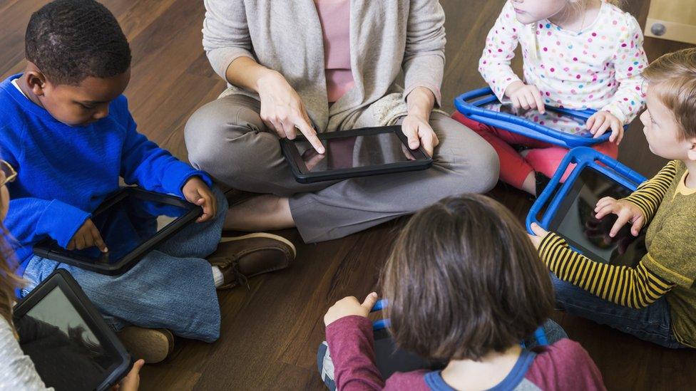 Children playing with computer tablets