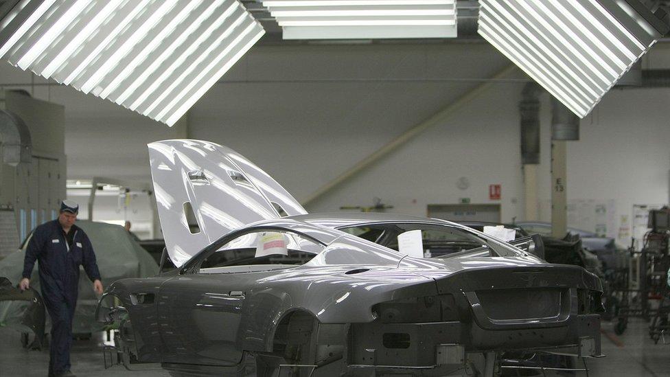 A man works on an Aston Martin