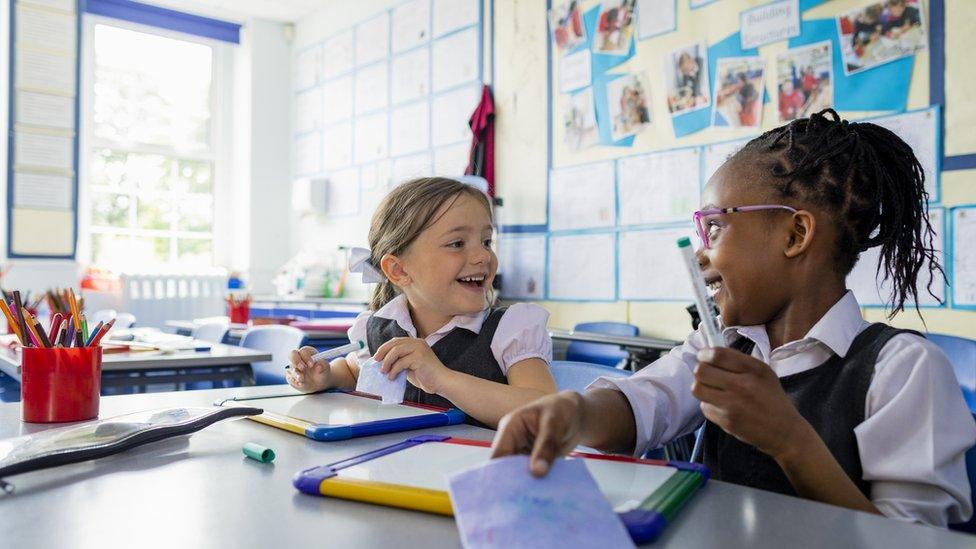 girls-chatting-at-school-smiling