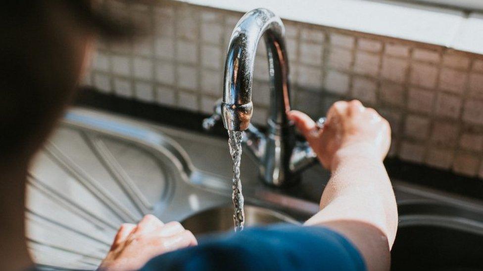 Man turns on water tap