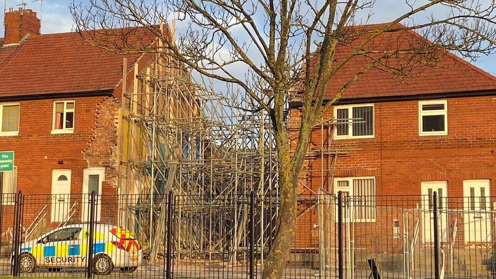 The space filled with scaffolding where the two flats were