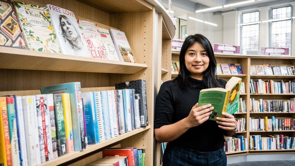 Woman standing by books in a library