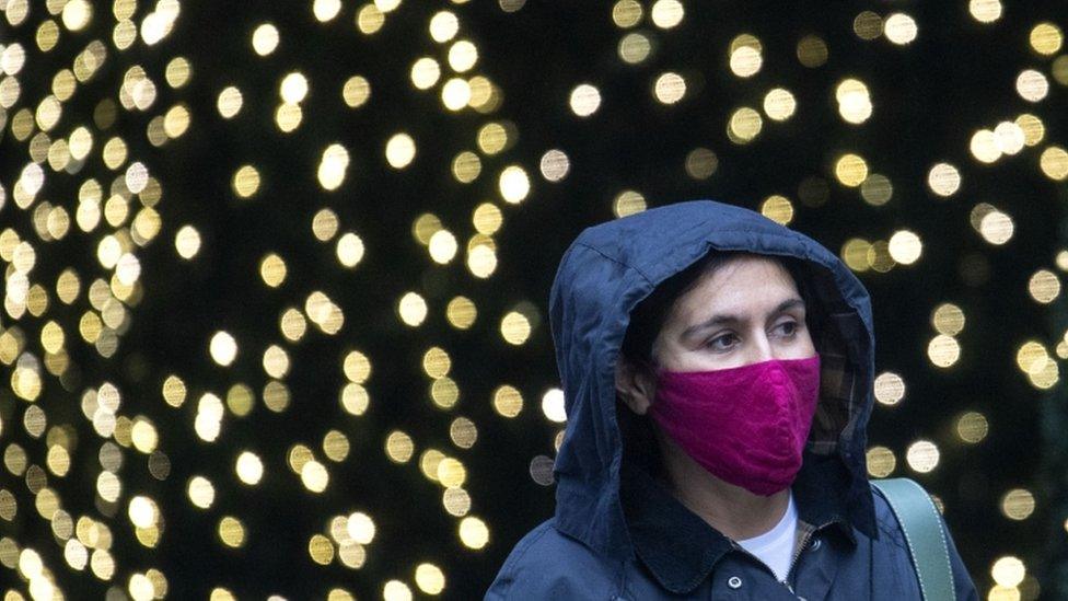 A woman walking with a face mask on