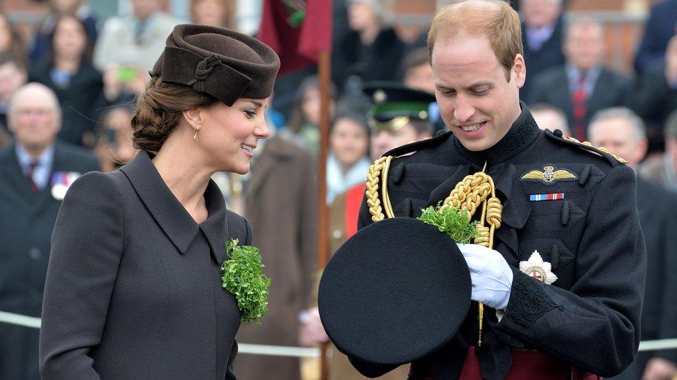 Kate Middleton and Prince William inspect his military uniform hat as he holds it in his hands