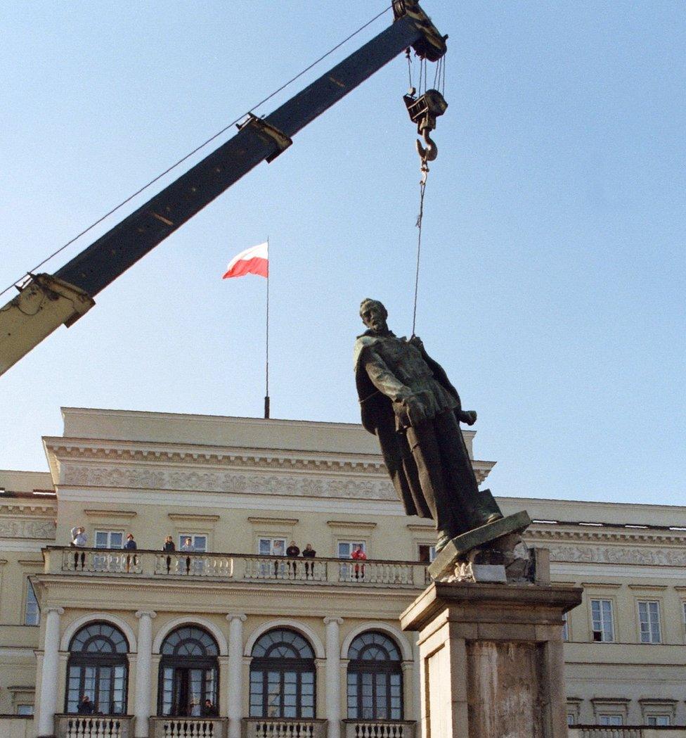 This file photo taken on 17 November 1989 in Warsaw shows people as the statue of Felix Dzerzhinsky, the founder of the first Soviet secret service, is taken down.