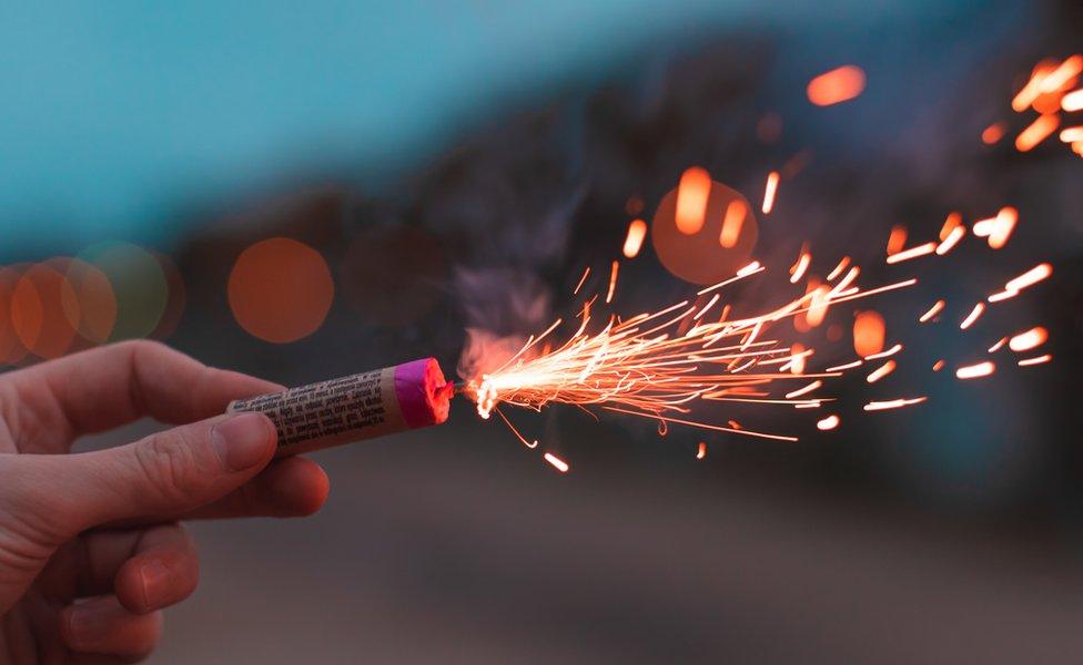 Hand holding a lit firework