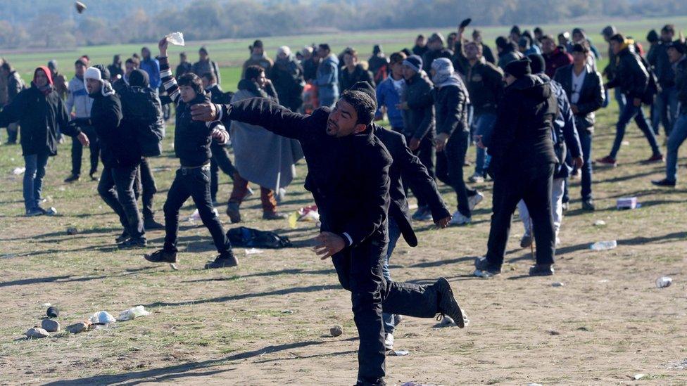 Migrants and refugees throw stones at each other during clashes as they wait to cross Greek-Macedonia border near Idomeni on December 3, 2015.