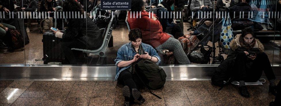 Travellers wait for their trains at the Lyon Part-Dieu railway station, on the first evening of a two days strike, on April 2, 2018 in Lyon