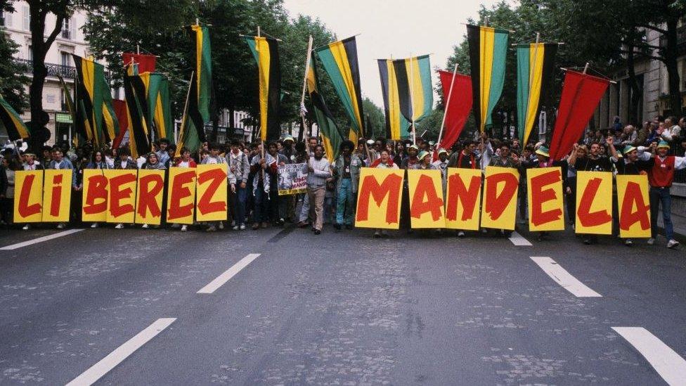 group of protesters with sign reading "liberez mandela"